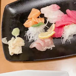 a black plate of sushi