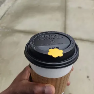 a hand holding a coffee cup