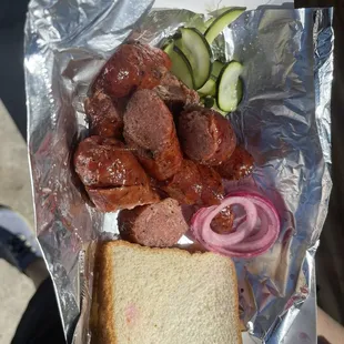 Sausage with red pickled onions and homemade pickles