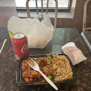 General Tso's chicken with a side of rice, an egg roll, and a Coke.