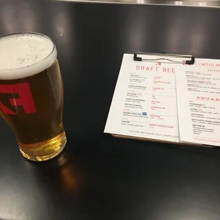 a glass of beer and a menu