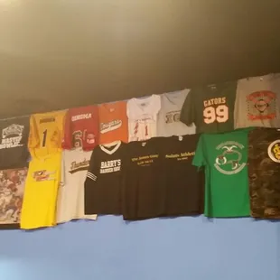 a variety of t - shirts hanging on a wall