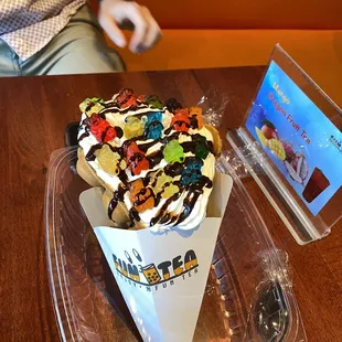a cup of ice cream with chocolate and candies