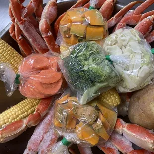 crab legs, corn, potatoes, carrots, and broccoli
