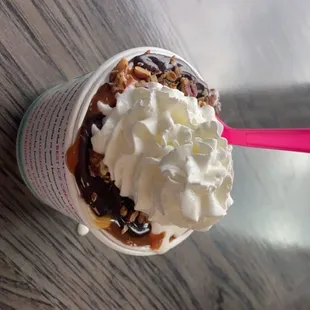an ice cream sundae with whipped cream and pecans