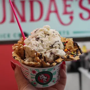 a hand holding a cup of ice cream