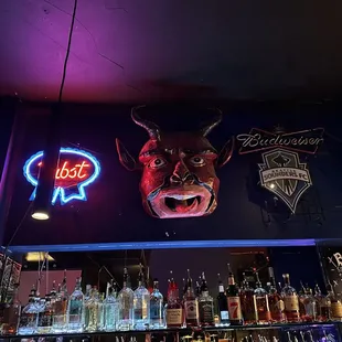 a bar with neon signs and a bull head on the wall