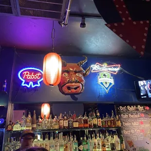 a bar with neon signs and liquor bottles