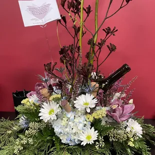 a flower arrangement with wine bottles