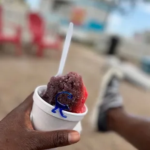 a hand holding a cup of ice cream