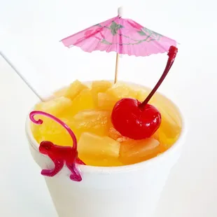 a cup of fruit with an umbrella
