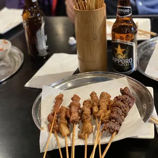 skewers of meat and beer on a table
