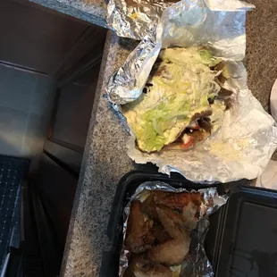 a sandwich and a burger on tin foil