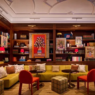 a living room with a couch, chairs, and bookshelves