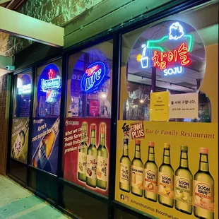 a neon sign in the window of a liquor shop