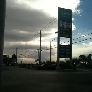 a gas station with a cloudy sky in the background