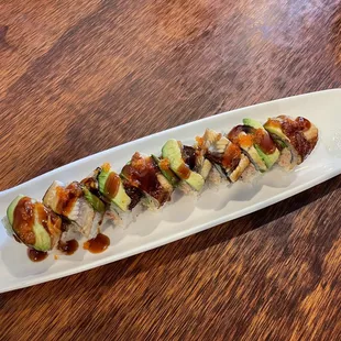 a long rectangular platter of food on a wooden table