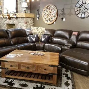 Dark leather reclining sectional. Shown with accent pillows and throw blanket.