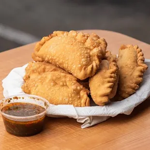 a plate of empanadas with dipping sauce