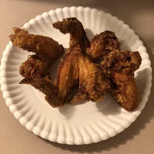 fried chicken wings on a paper plate