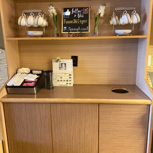 a kitchen counter with a tea pot and cups on it