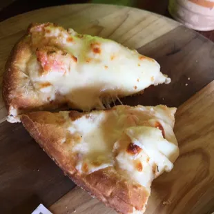 two slices of pizza on a cutting board