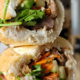 a hand holding a half eaten sandwich