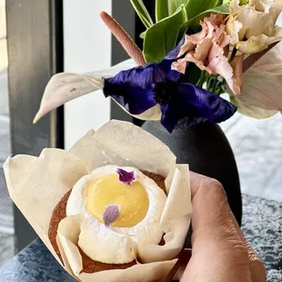 a person holding a cupcake with an egg in it