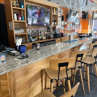 a bar with chairs and a television
