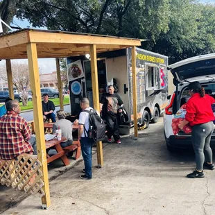 a group of people loading their food into the back of a car