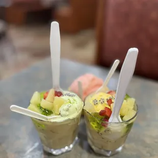 two glasses of fruit salad on a table