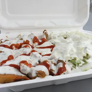 a container of entrees and a salad