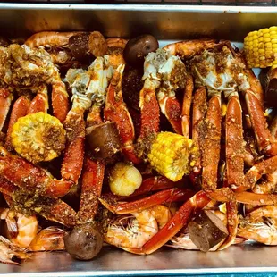 a pan of crab legs and corn