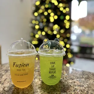 two drinks sitting on a table in front of a christmas tree
