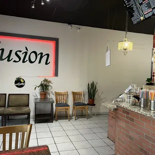 a view of a restaurant with a neon sign on the wall