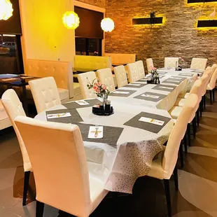 a long dining table with white chairs