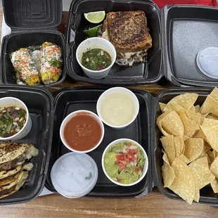 From bottom left: Beef Shank Birria Quesadilla, Street Corn, Beef Shank Birria Grilled Cheese, House Made Chips, Guac, Salsa, Queso 050924