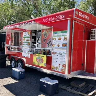 a red food truck parked in a parking lot