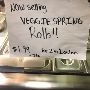 a sign saying you selling veggie spring rolls
