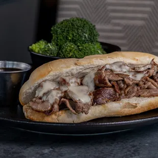 a beef sandwich with a side of broccoli