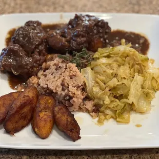 Oxtails, rice and peas, cabbage and plantains.