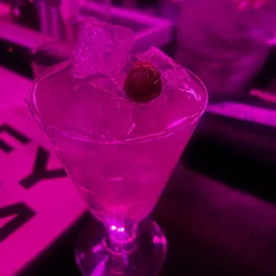 a pink cocktail with a cherry in it