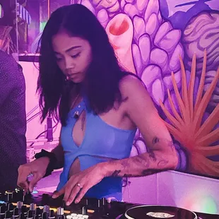 a woman in a blue dress mixing music