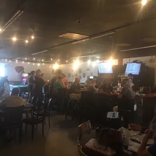 people sitting at tables and watching televisions