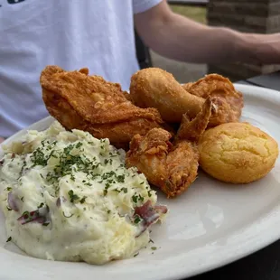 a plate of fried chicken, mashed potatoes, and cornbreads