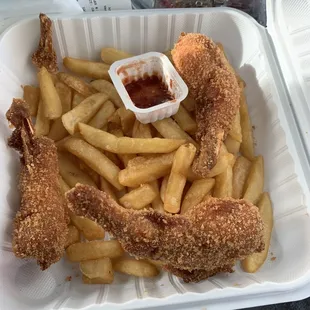 fried chicken and french fries in a styrofoam container
