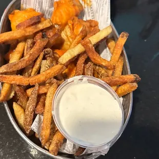 a basket of fries and a side of ranch dip