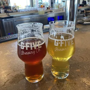 two glasses of beer on a bar
