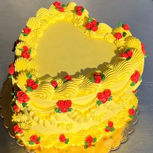 a yellow cake with red roses