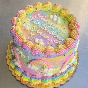 a rainbow cake with a happy birthday message